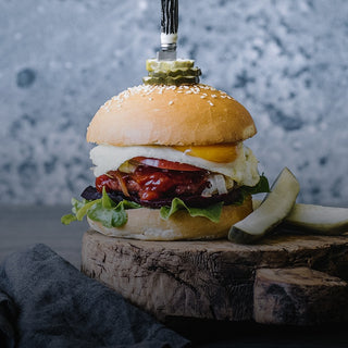 Hamburger with a mcclure pickle on a wooden block